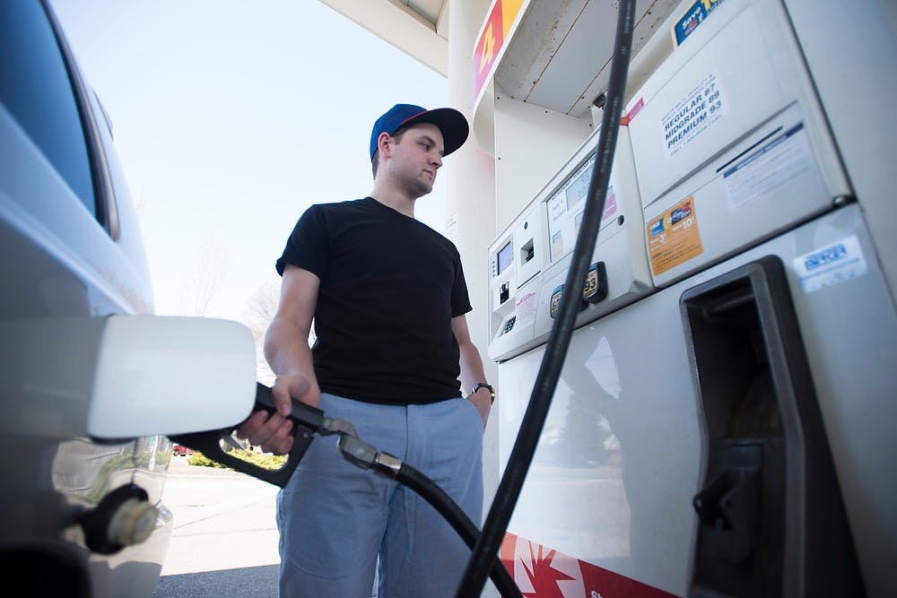 <p>Journalism junior and State News reporter Andy Merkle pumps his gas April 17, 2015, at the Shell gas station, 1831 E. Grand River Ave. Merkle spent about $35.01 on gas this month. </p>