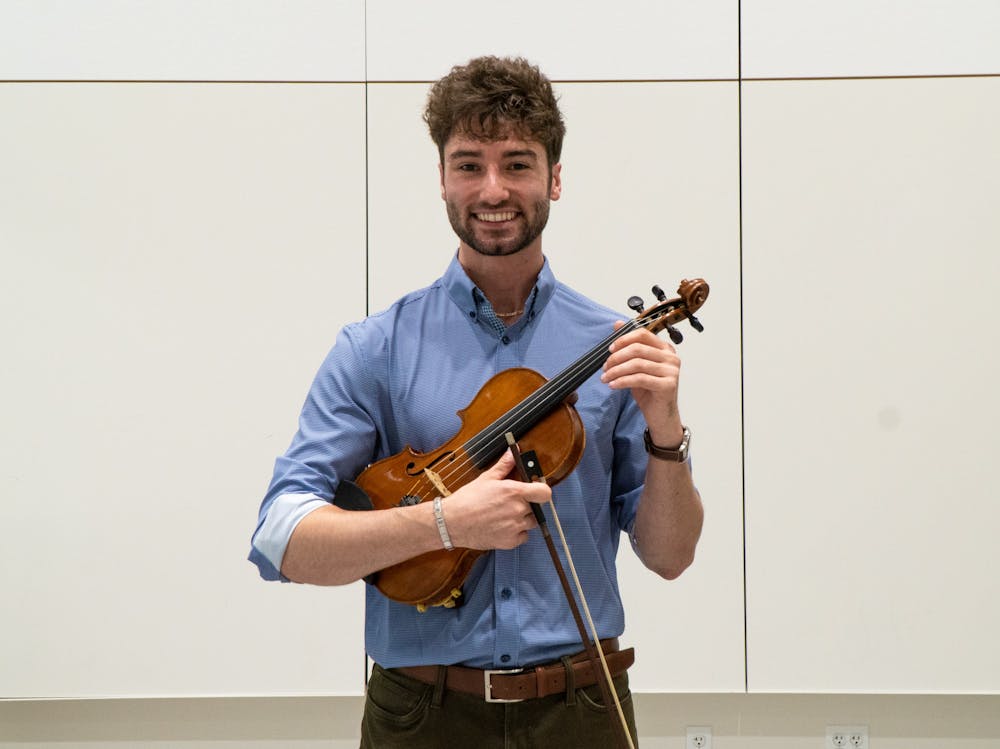 <p>Human biology senior James Cozzi poses with his violin in a rehearsal room at Michigan State University&#x27;s College of Music on Sept. 21, 2022. </p>