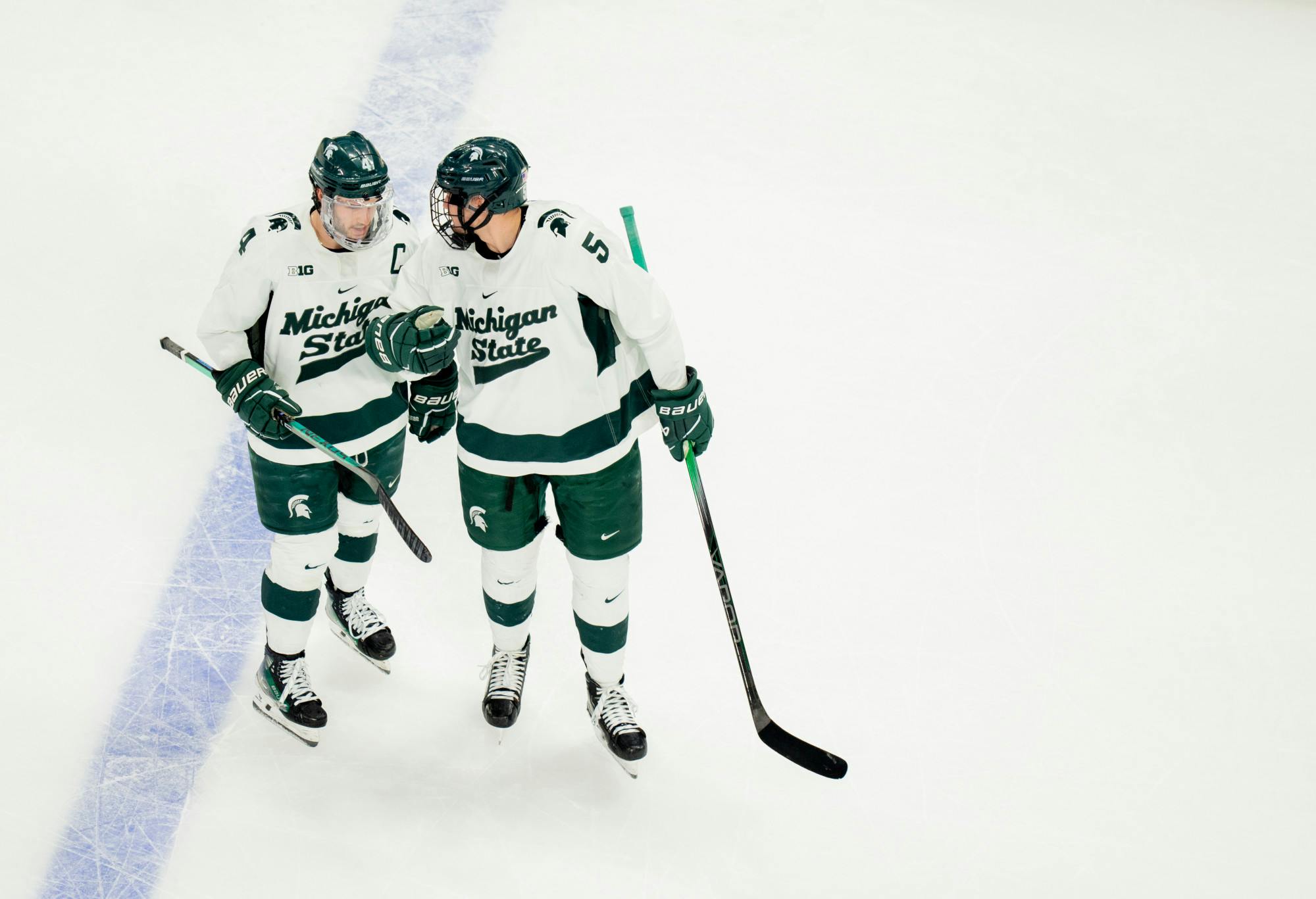 <p>MSU defenseman and captain Nash Nienhuis (left) and forward Artyom Levshunov speak briefly in between plays at Little Caesars Arena on Saturday, Feb. 10, 2024, for the "Duel in the D." MSU came away with a 3-2 victory after resisting a late-game U of M comeback.</p>
