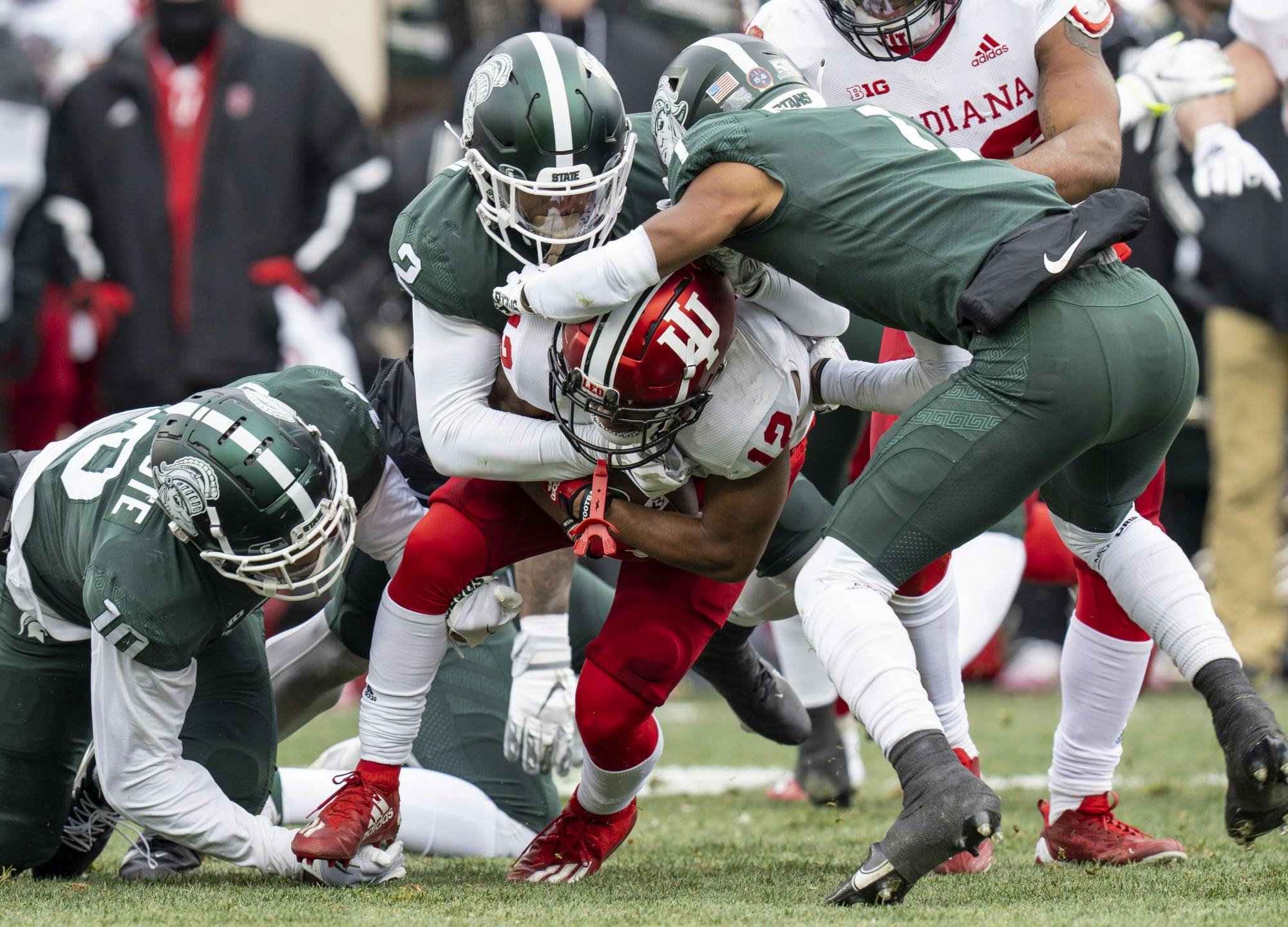 Senior defensive end Khris Bogle, 2, and freshman safety Jaden Mangham, 1, stop Jaylin Lucas, 12, during Michigan State’s last game at home against Indiana on Saturday, Nov. 19, 2022 at Spartan Stadium. Indiana ultimately beat the Spartans, 39-31.