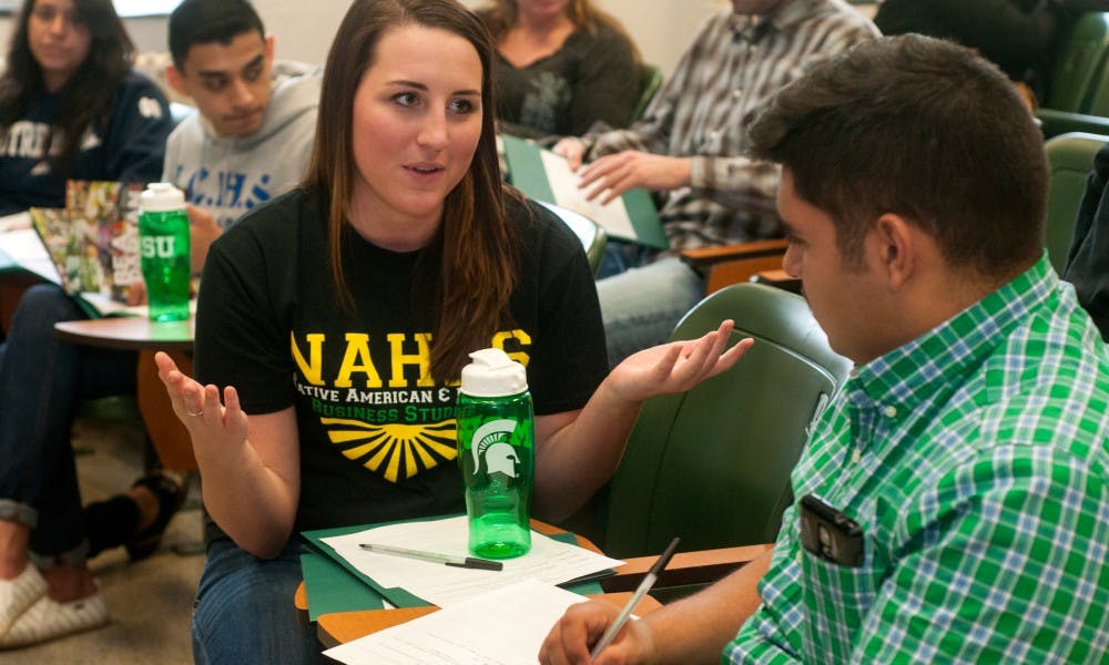 <p>Marketing senior Ashley Johns helps Grand Rapids resident Omar Cuevas, 17, write his resume on Oct. 23, 2015 at the Natural Sciences building. The Native American and Hispanic Business Students put on an event to help Hispanic students from the surrounding areas learn more about MSU, the college application process and presentation and resume skills. </p>