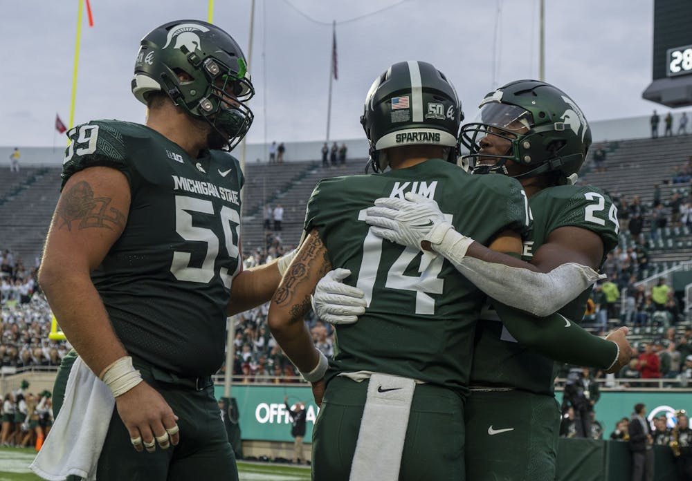 <p>Nick Samac, 59, Noah Kim, 14, and Elijah Collins, 24, celebrate Michigan State’s touchdown during their match against Minnesota on Saturday, Sept. 24, 2022. The Gophers ultimately beat the Spartans, 34-7.</p>