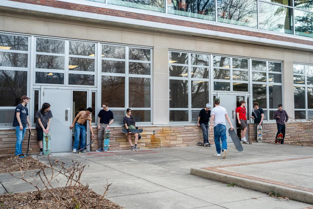 Members of MSU Skate Club laugh and converse between tricks during skate club outside of Shaw Hall on Michigan State University’s campus in East Lansing, Mich., on March 20, 2026, 