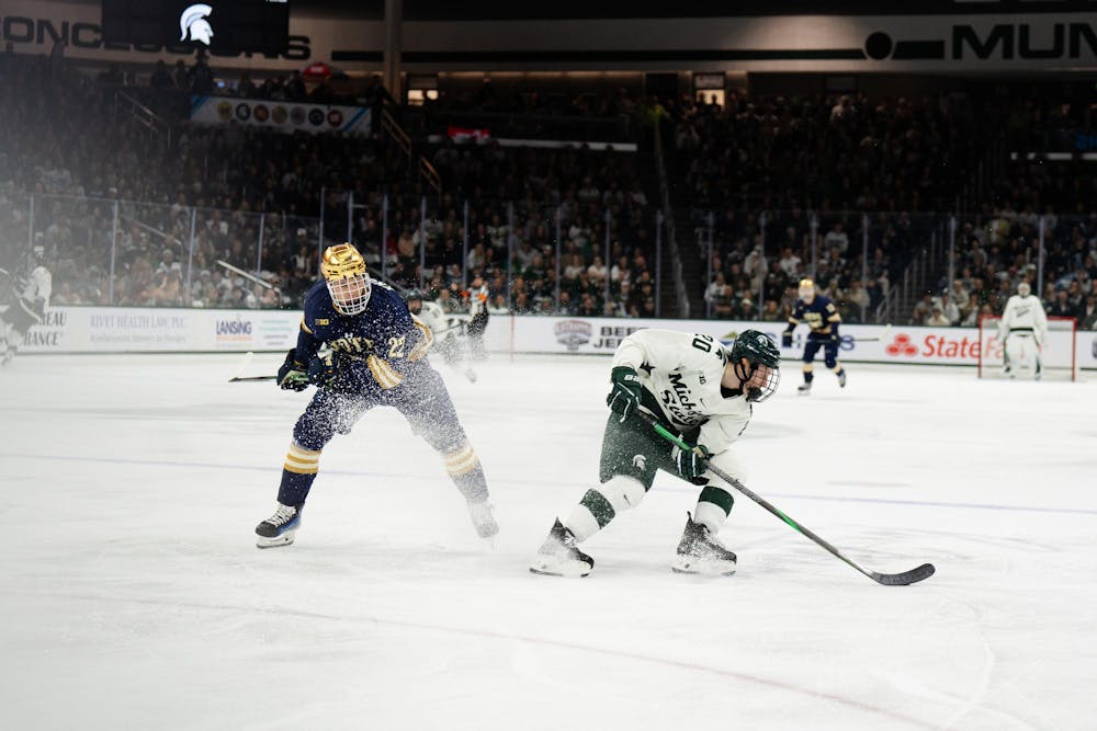 <p>Michigan State junior forward Daniel Russell (20) beats Notre Dame sophomore forward Cole Knuble (22) to the puck at Munn Ice Arena on March 15, 2025. The Spartans took a 1-0 victory against the Fighting Irish, advancing to the Big Ten Championship.</p>