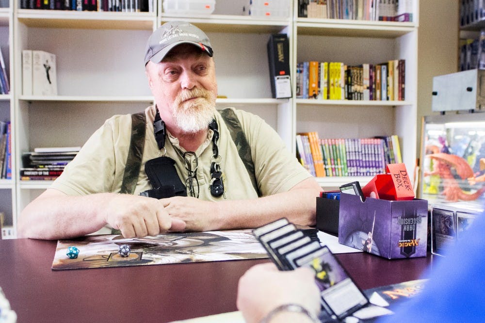 Jim McNitt of Lansing plays a game of Magic the Gathering inside of Capital City Collectibles on Monday afternoon. McNitt said he was playing with his goblin deck against shop owner and Lansing resident Peter Ryan's event deck. Natalie Kolb/The State News