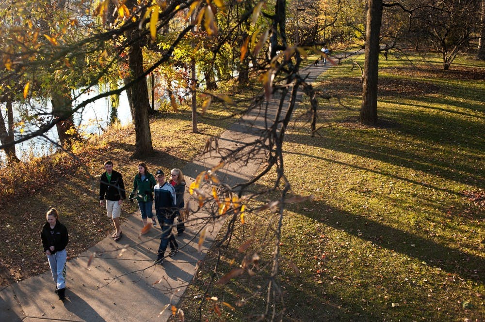 	<p>Pedestrians walk on the banks of the Red Cedar River near the Main Library, Sunday, Nov. 11, 2012. East Lansing and the nearby areas enjoyed warmer weather over the weekend, with temperature high reached near 70 degrees on Sunday. Justin Wan/The State News</p>