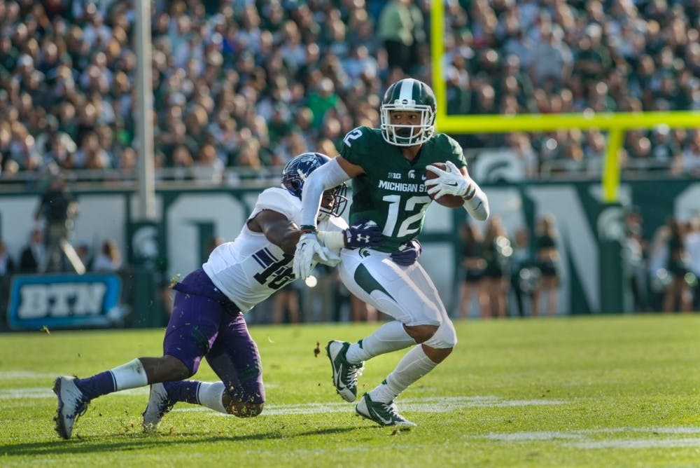 Senior wide receiver R.J Shelton (12) catches the ball and is then tackled by Northwestern quarterback Clayton Thorson (18) during the game against Northwestern on Oct. 15, 2016 at Spartan Stadium. The Spartans were defeated by the Wildcats, 54-40.