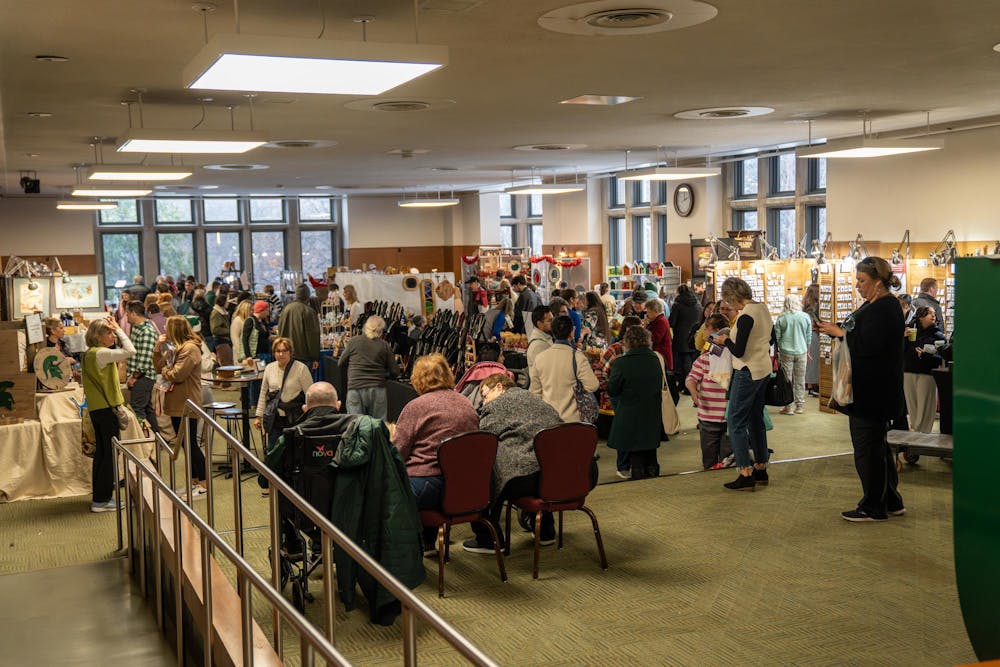 Visitors move through vendor booths at Michigan State’s annual winter arts and craft show at the Union on campus in East Lansing, Mich., on Saturday, Dec. 6, 2025.