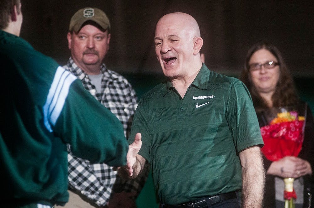 	<p>Head coach Tom Minkel shakes senior 165 pounder Robert Nash as he walks up with his family to be recognized for Senior Day before the meet. The Spartans defeated the Comets, 40-0. Erin Hampton/The State News</p>