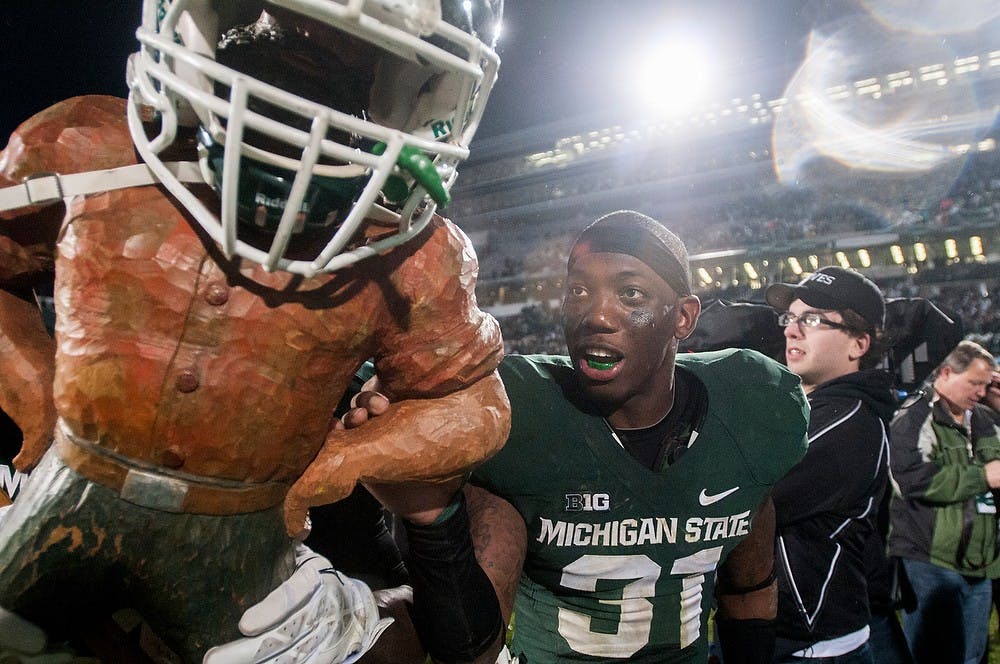 	<p>Senior cornerback Darqueze Dennard celebrates with the Paul Bunyan trophy after the game against Michigan on Nov. 2, 2013, at Spartan Stadium. The Spartans defeated the Wolverines, 29-6. Khoa Nguyen/The State News</p>