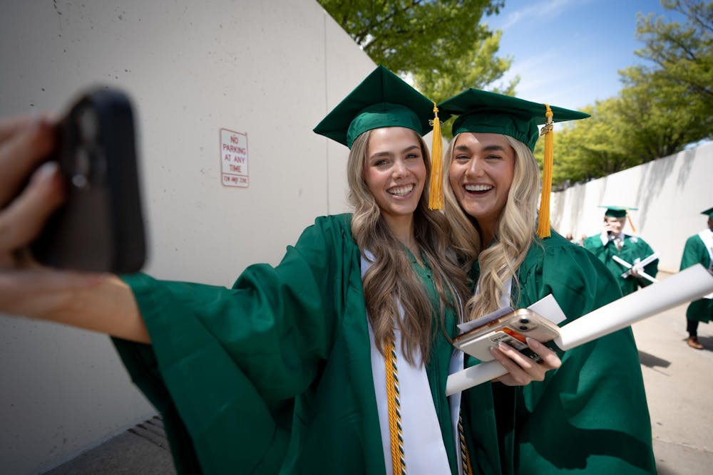 Graduates take a selfie together in the Breslin Center tunnel after commencements on May 3, 2025.