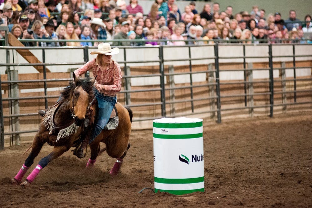 Animal science sophomore Hanna Menne rides her horse, Fancy, as she competes in barrel race during the annual Spartan Stampede on Feb. 20, 2016 at the MSU Pavilion for Agriculture and Livestock Education.