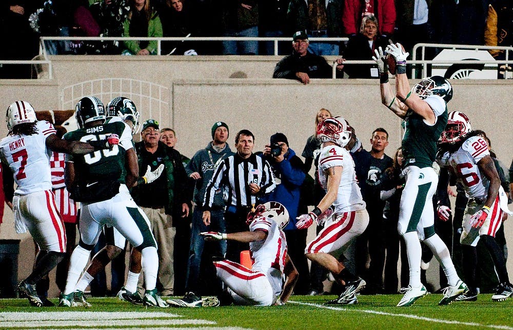 	<p>Senior wide receiver Keith Nichol catches a tipped ball which he took to the endzone for the win over the Badgers. The Spartans defeated Wisconsin, 37-31, on Saturday night at Spartan Stadium. Josh Radtke/The State News</p>