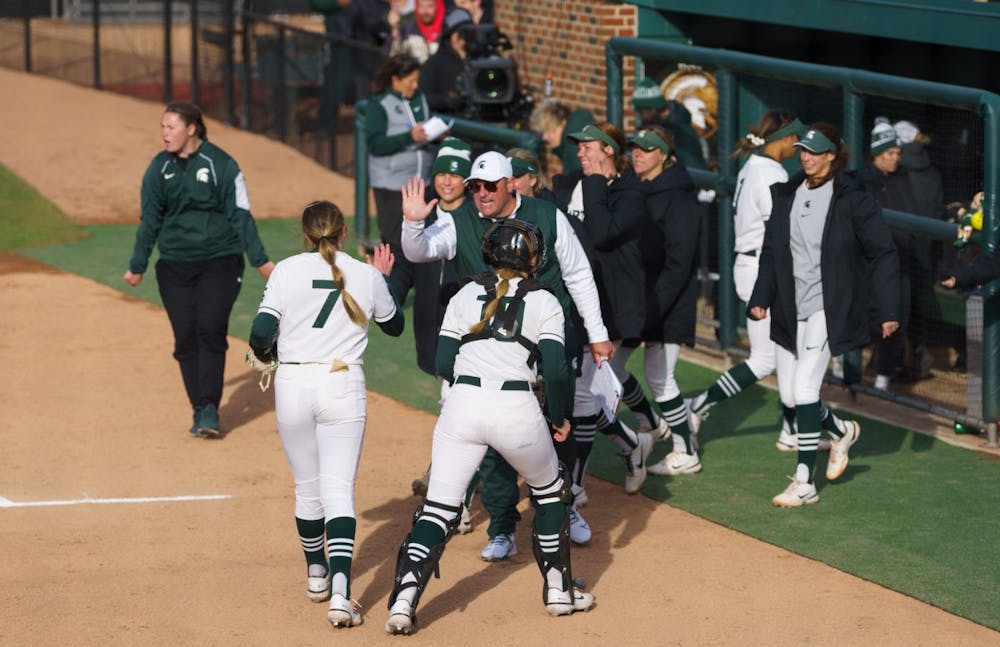 <p>Michigan State sophomore pitcher Ashley Miller (7) gives a high five to assistant coach Ben Sorden after stopping Michigan the entire second inning. Michigan State lost 3-0 to Michigan at the Secchia Stadium, on April 19, 2022.</p>