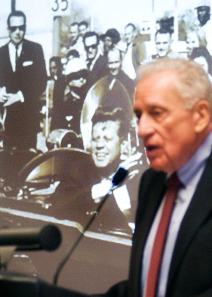 	<p>U.S. Secret Service Agent Clint Hill speaks about details of the assassination of former President John F. Kennedy on Nov. 22, 1963 in Dallas, as he was present at the time, seen in the upper left hand of the projected photograph riding behind the president’s vehicle. Hill was speaking with the co-authors of The Kennedy Detail, U.S. Secret Service Agent Gerald Blaine and Lisa McCubbin, Tuesday morning in the Union.</p>