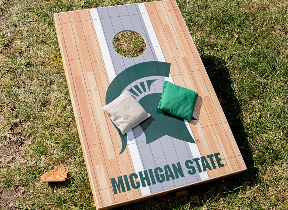 Two bags sit on a cornhole board, at a tailgate, prior to the Spartans' game against Nebraska on Sept. 25, 2021.
