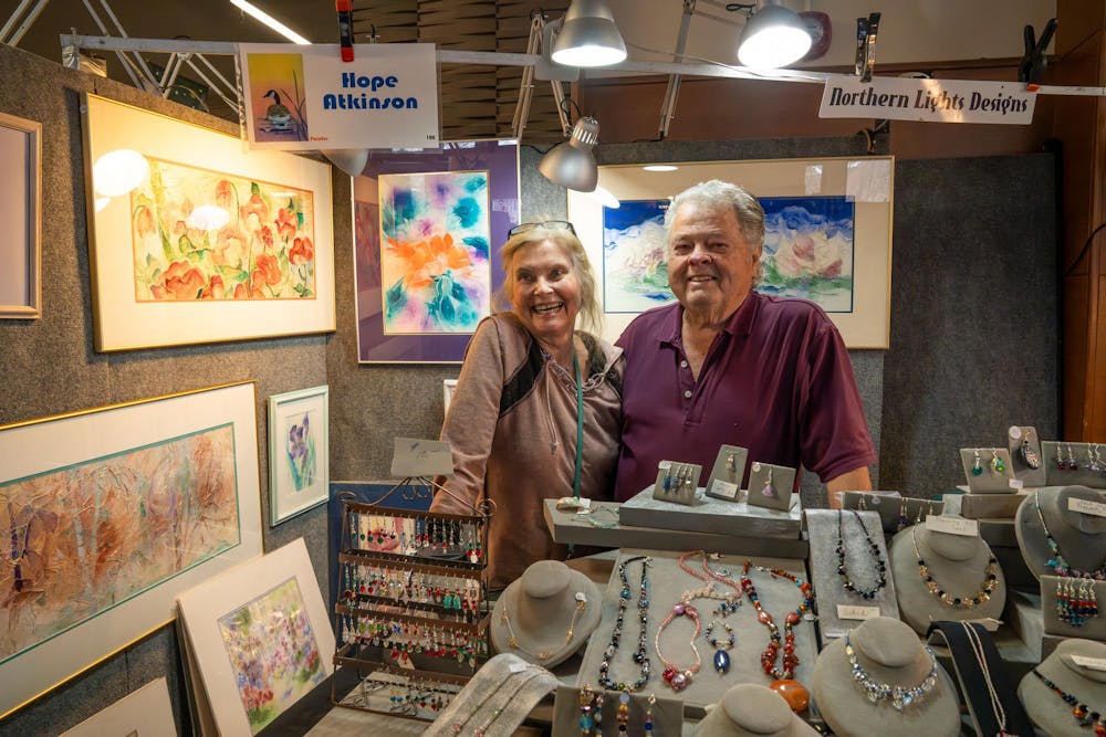 Hope and Guy Atkinson stand at their table where they sell Hope’s paintings made with rice paper, along with handmade beaded jewelry, during Michigan State’s annual winter arts and craft show at the Union on campus in East Lansing, Mich., on Saturday, Dec. 6, 2025.
