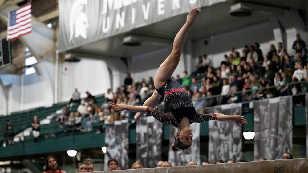 Devin Wright, junior from Maryland, performs a back aerial on the balance beam during the MSU tri-meet at Jenison Field House on Sunday, Feb. 15, 2026.