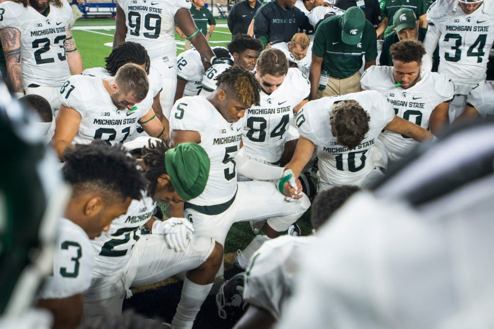 MSU players bow their heads in prayer after the game against Notre Dame on Sept. 17, 2016 at Notre Dame Stadium in South Bend, Ind. The Spartans defeated the Fighting Irish, 36-28.