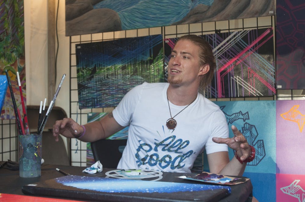 Walled Lake resident Kevin Pacynski talks about his art during Common Ground Music Festival on July 9, 2016 at Adado Riverfront Park in Lansing, Mich. Pacynski started painting four years ago and runs his own business called KPac Kreations.  