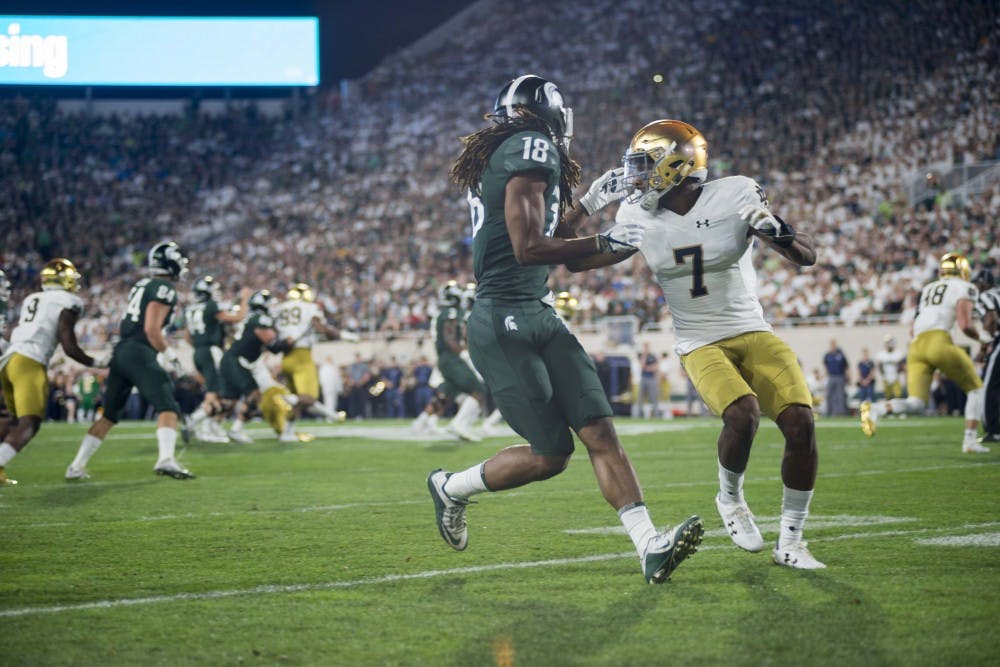 <p>Junior wide receiver Felton Davis III (18) looks over his shoulder for a pass during the game against Notre Dame on Sept. 23 at Spartan Stadium. The Irish defeated the Spartans 38-18.</p>