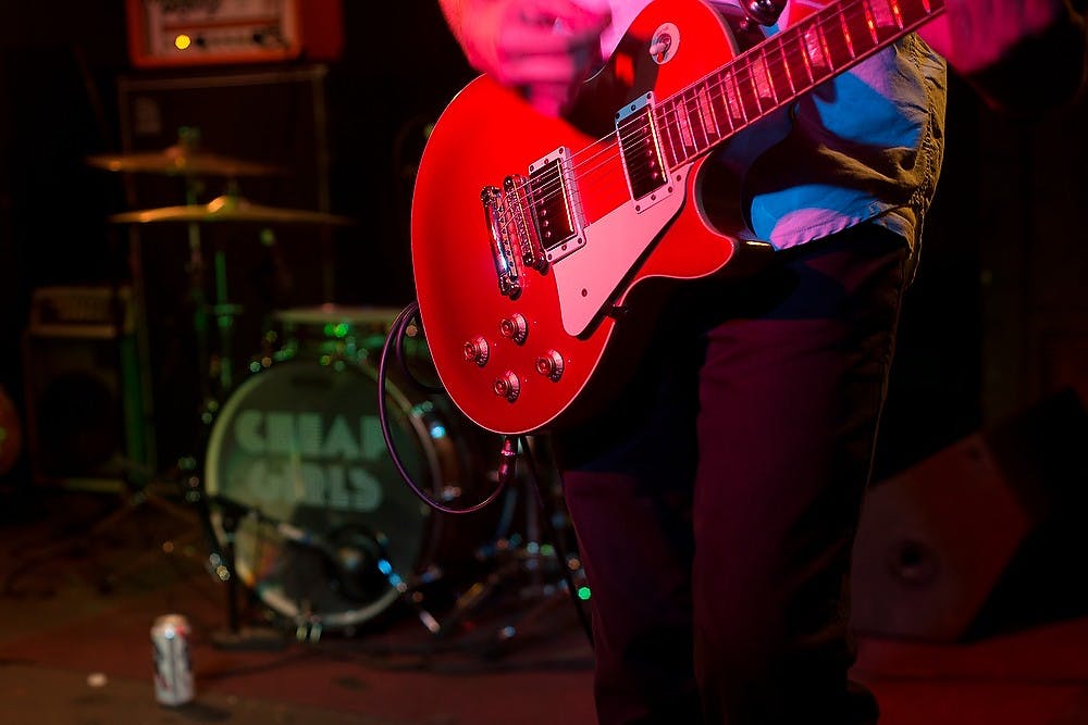 <p>Cheap Girls guitarist Adam Aymor performs with his guitar Sept. 5, 2014, during the band's performance at Macs Bar, 2700 E Michigan Ave., in Lansing. The concert was relocated from outside of the Eli and Edythe Broad Art Museum to Macs Bar due to stormy weather. Erin Hampton/The State News </p>