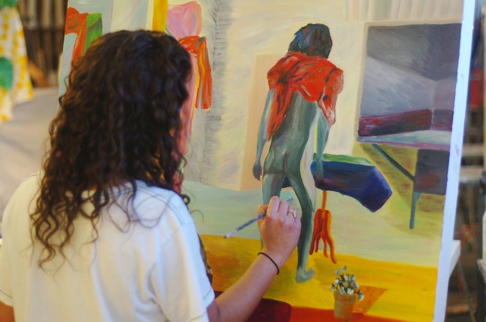 <p>Studio art sophomore Alexandra Bertakis paints a still-life portrait for her studio art class March 26, 2014, at the Kresge Art Center. Bertakis said the purpose of the assignment is to exaggerate reality with imaginative colors. Emily Jenks/The State News</p>