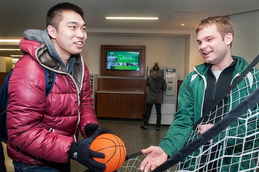 	<p><span class="caps">MSU</span> Federal Credit Union employee Chad Schaberg, right, explains to economics senior Zihou Liu the rules of a game during the re-opening of the Union on Jan. 15, 2013. Free cake and activities were provided at the event. Julia Nagy/The State News</p>