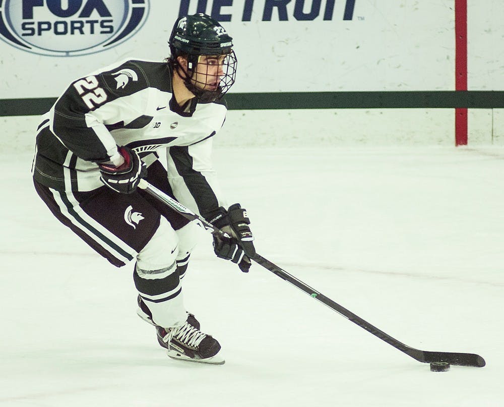 <p>Sophomore forward JT Stenglein guides the puck down the ice Oct. 17, 2014, during a game against Massachusetts at Munn Ice Arena. The Spartans defeated the Minutemen, 5-3. Erin Hampton/The State News</p>