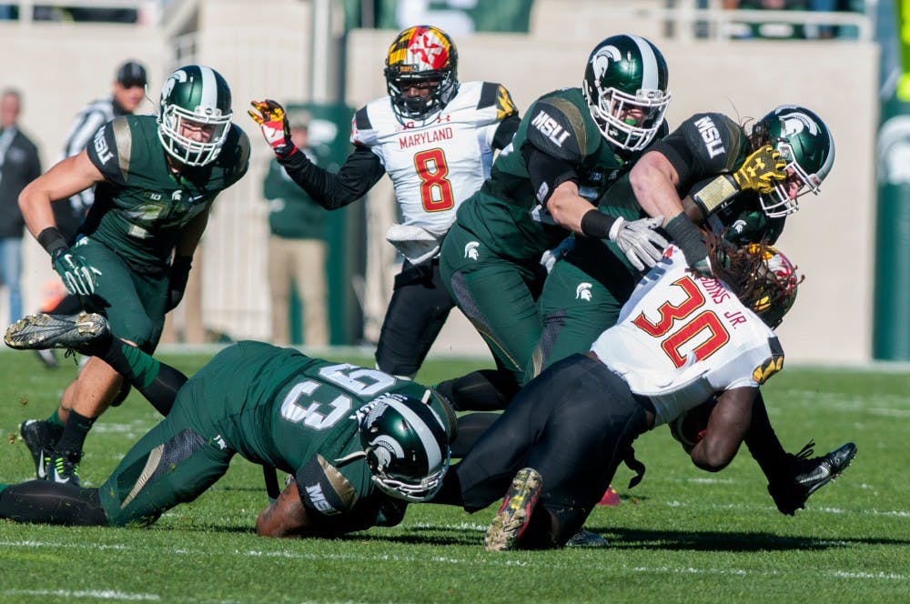 <p>Sophomore linebacker Jon Reschke and junior linebacker Riley Bullough, right, tackle Maryland running back Kenneth Goins Jr. in the first quarter during the game against Maryland on Nov. 14, 2015 at Spartan Stadium. The Spartans defeated the Terrapins, 24-7.</p>