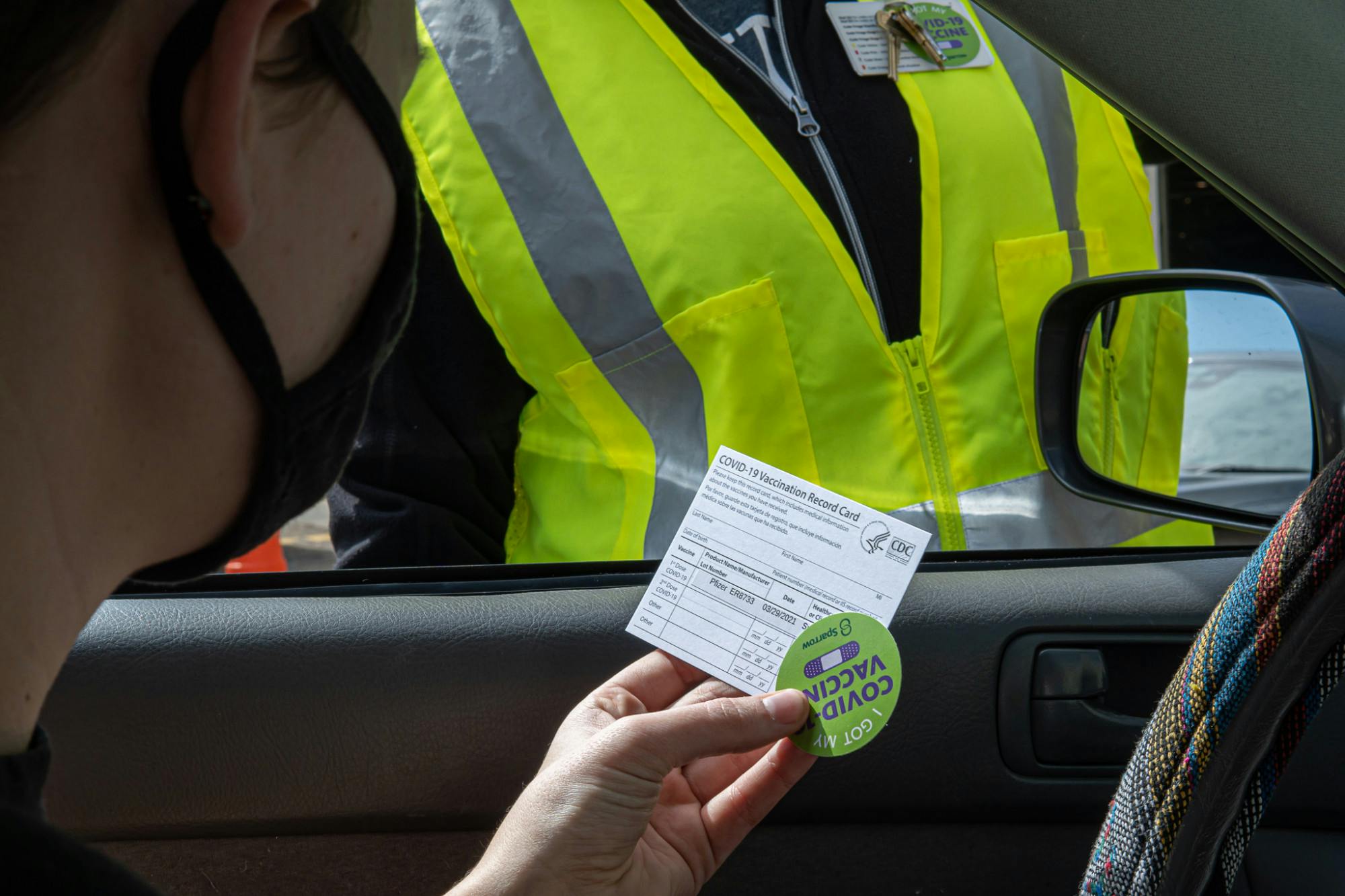 <p>Journalism junior Maddie Monroe is handed her vaccine card and a sticker after getting the COVID-19 vaccine on March 29, 2021.</p>