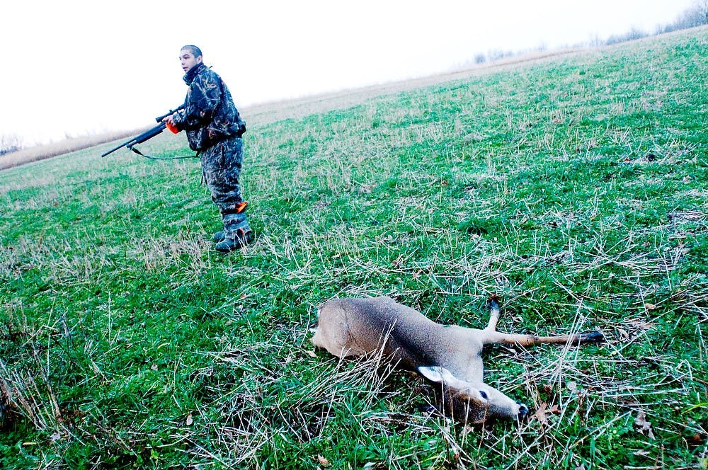 	<p>In this file photo from Nov. 16, 2011, Mason resident Chris Ruiz walks off of the field to trace other prey after gunning down a deer in Dansville, Mich. State News File Photo</p>