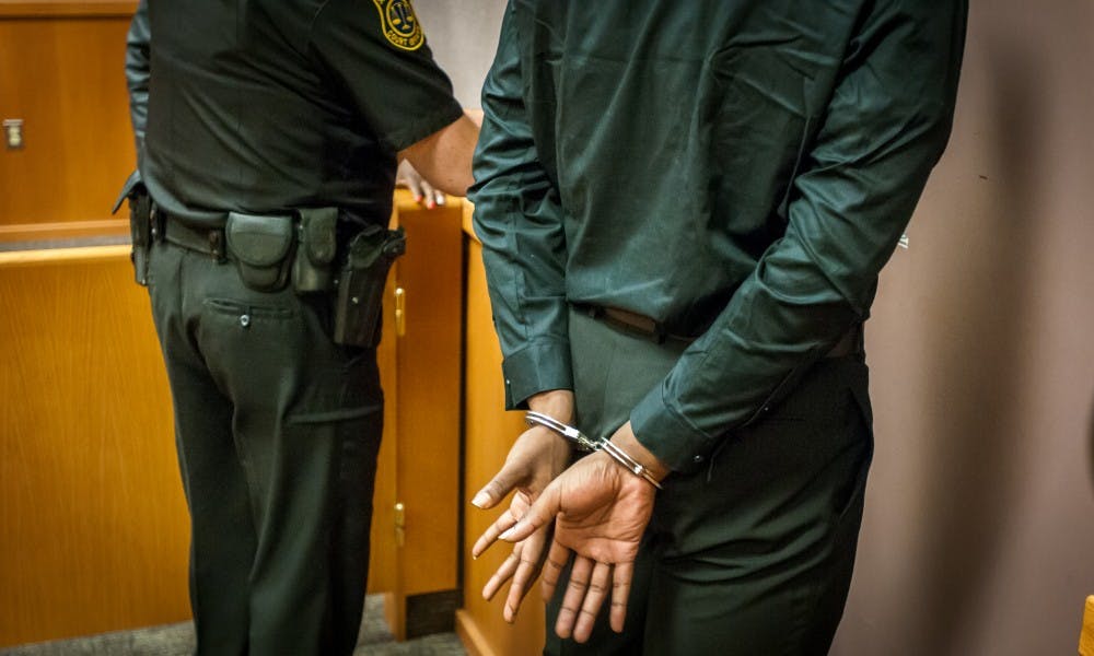 Ex-MSU football Player Josh King's hands are pictured as he is taken into custody on June 7, 2017 at 54-B District Court in East Lansing.