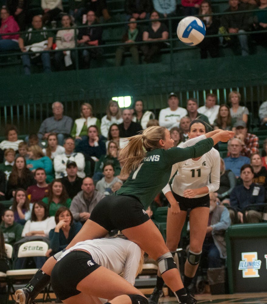 <p>Senior libero Kori Moster digs the ball as she steps over freshman setter Rachel Minarick during the game against Minnesota on Nov. 7, 2014 at Jenison Field House. The Gophers defeated the Spartans, 3-1. Aerika Williams/The State News</p>