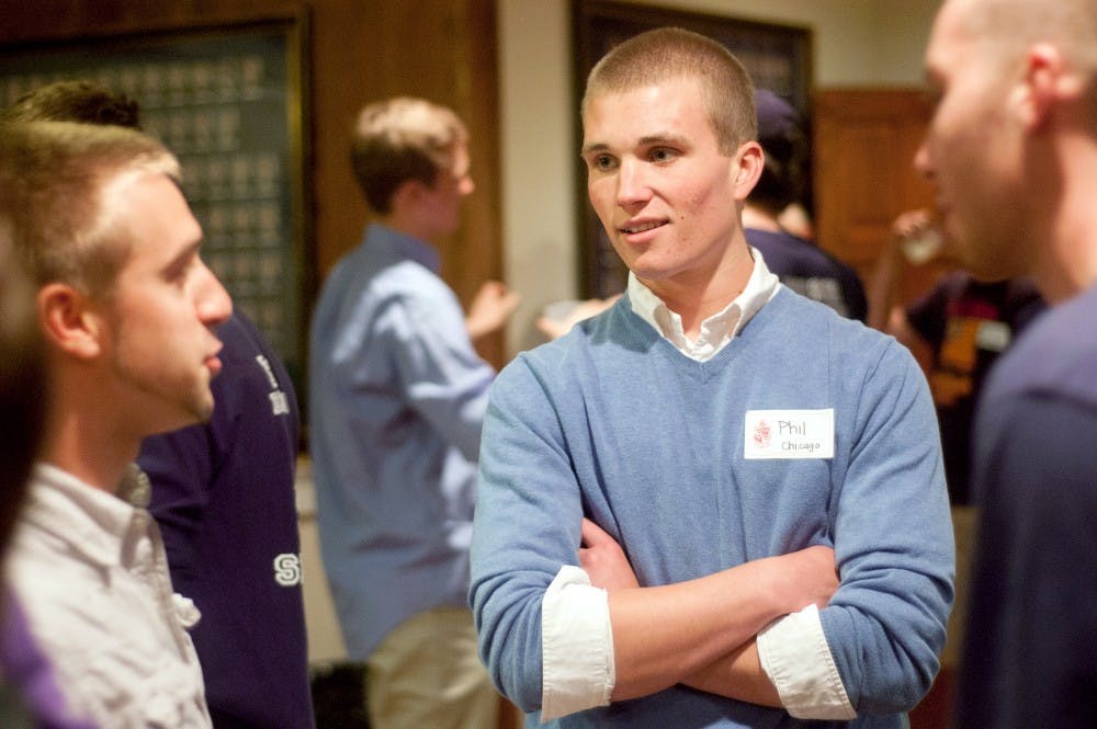 Human biology freshman Phil Pray talks with members of Delta Chi fraternity on Tuesday, Sept. 18. Delta Chi is one of 27 fraternities participating in Rush Week. Omari Sankofa/The State News