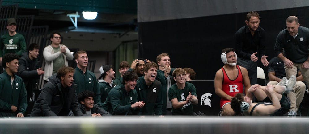 Rising senior Andy Hampton and the MSU wrestling team celebrate a point during the dual match at Jenison Field House on Feb. 13, 2026.