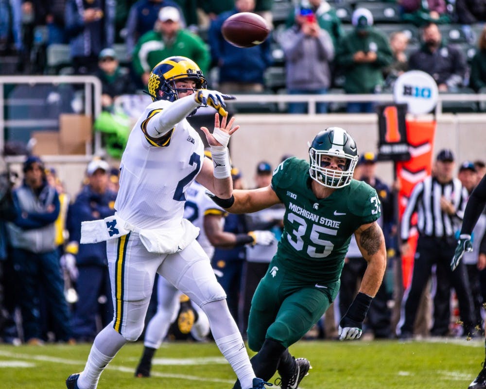 <p>Michigan quarterback Shea Patterson (2) throws a pass as he's pursued by junior linebacker Joe Bachie (35) during the game at Spartan Stadium Oct. 20. The Wolverines defeated the Spartans, 21-7.</p>
