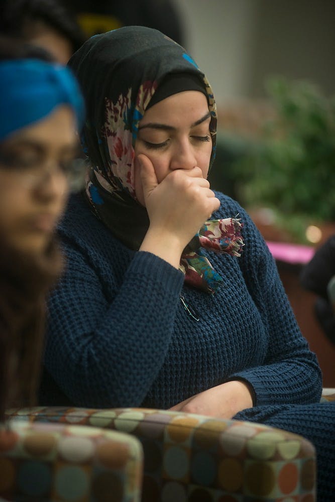 <p>Graduate student Susan Edlibi sits in silence Feb. 11, 2015, as graduate student Laya Charara speaks about the loss of three North Carolina students during the vigil held in the basement of the Radiology Building, 846 Service Rd. Muslim victims, Deah Barakat, 23, his wife, Yusor Abu-Salha, 21, and her sister, Razan Abu-Salha, 19, were shot and killed in their home in North Carolina Tuesday night. Emily Nagle/The State News</p>