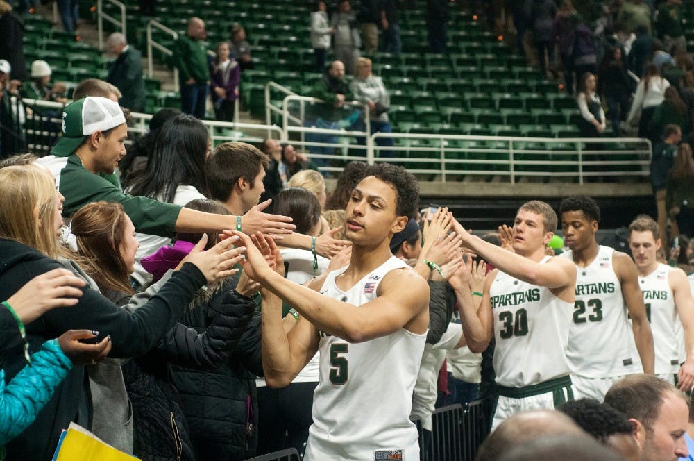 From left to right, senior guard Bryn Forbes, junior forward Matt Van Dyk and freshman forward Deyonta Davis high five fans at the end of the home men's basketball game against Binghamton on Dec. 5, 2015 at the Breslin Center. The Spartans defeated the Bearcats, 76-33.  