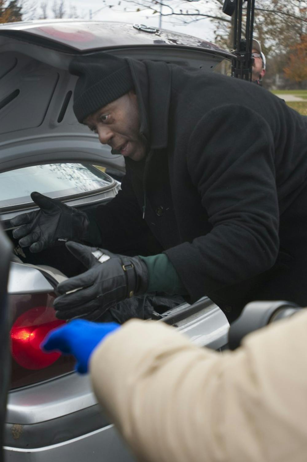 Earvin "Magic" Johnson Jr. loads supplies into the back of a car on Nov. 20, 2016 at Everett High School in Lansing. Johnson was there for Holiday Hope Lansing which gives supplies to families in need.