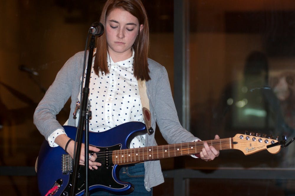 English junior Stefanie Haapala performs an untitled song during Story Lines, an event put on by Haapala, on Dec. 3, 2015 at the (SCENE) Metrospace, 110 Charles Street, East Lansing. Haapala is a singer-songwriter and performed two of her songs for the crowd, one of which she had only written the night before. 