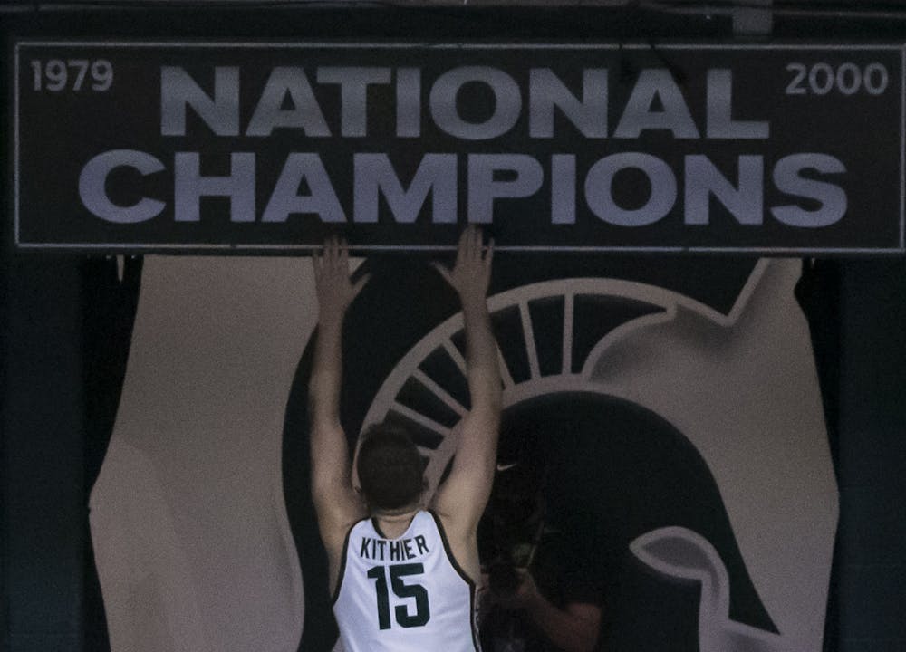 Junior forward Thomas Kithier (15) jumps up to reach the National Champions banner after the team's victory. Michigan State triumphed over Notre Dame, 80-70, on Nov. 28, 2020. 