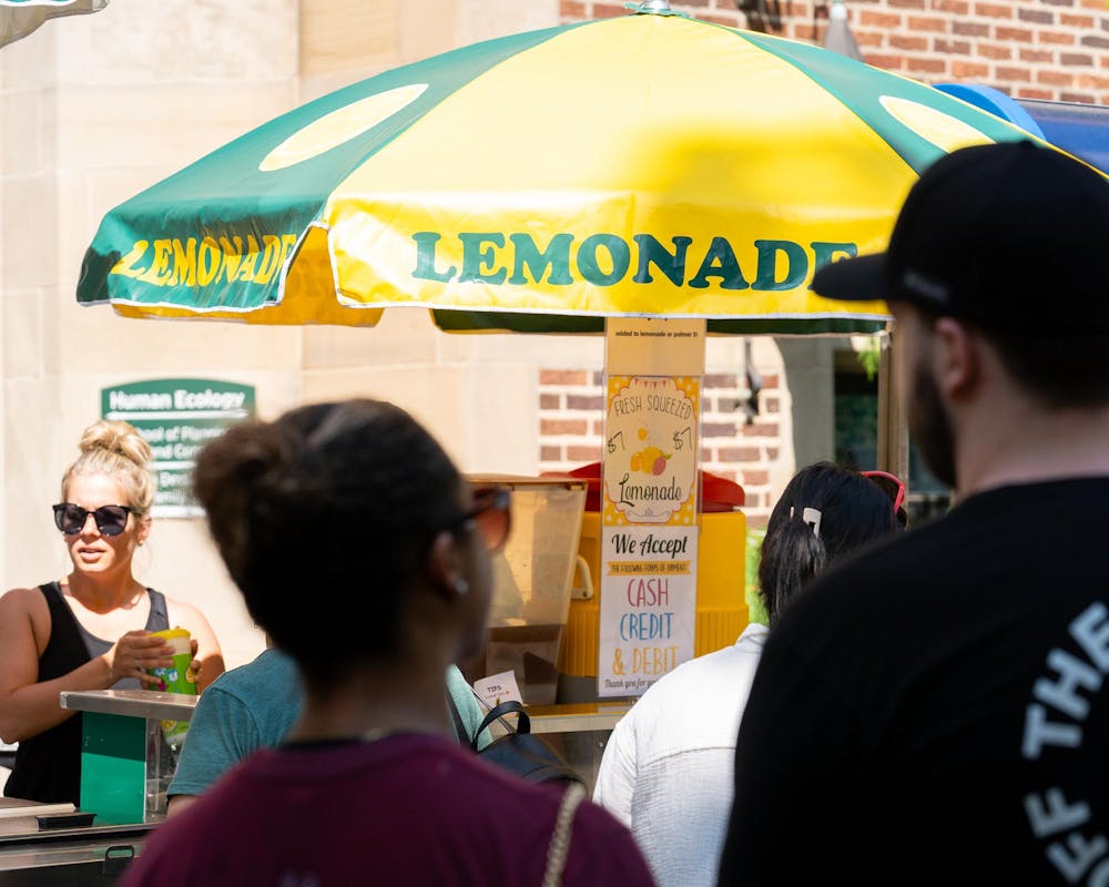 Visitors wait in line for refreshments during the East Lansing Art Festival at Michigan State University on May 18, 2024.