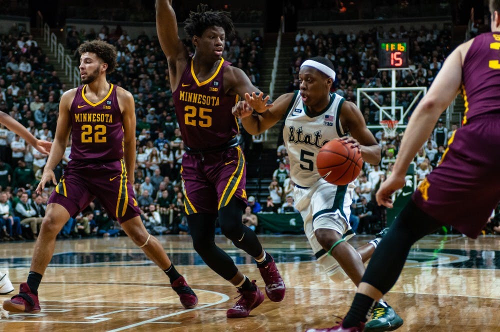 <p>Junior guard Cassius Winston (5) drives on Minnesota's Daniel Oturu. MSU beat Minnesota 79-55 at the Breslin Center on Feb. 9, 2019.</p>