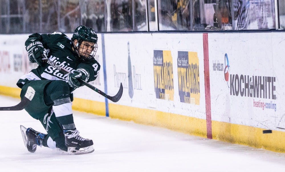 <p>Junior defenseman Butrus Ghafari (44) passes the puck up the boards during the game against Michigan on Feb. 8, 2019, at Yost Ice Arena. The Spartans fell to the Wolverines, 5-3.</p>
