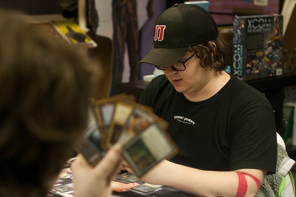 <p>Media and information senior Marley Mazzara, left, plays media and information sophomore Ty Hill Feb 27, 2015, during a gathering of Magic players at Hollow Mountain Comics, 611 E. Grand River Ave. Kennedy Thatch/The State News</p>