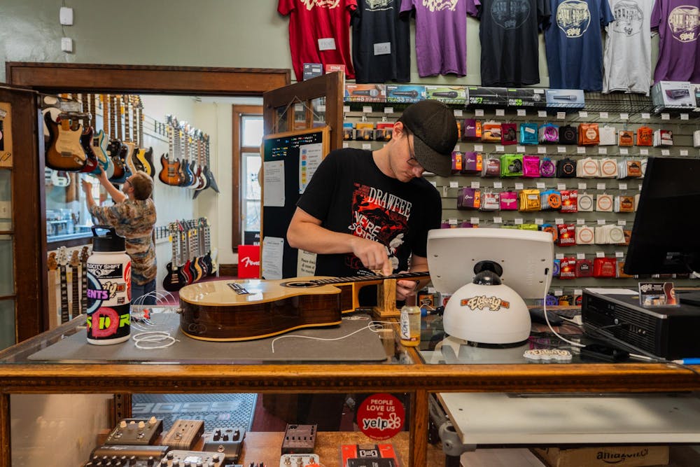 <p>Elderly Instruments salesman Louis Konkoly cleans a guitar at the shop on Friday Oct. 27, 2023. The music store located at 1100 N Washington Ave, Lansing, MI, has been open at that location since the 80's.</p>