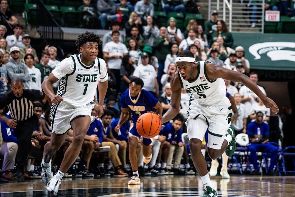 <p>Michigan State University freshman guard Jeremy Fears Jr. (1) cheering on sophomore guard Tre Holloman (5) as he makes his way across the court for the game against Alcorn State University at the Breslin Center on Nov. 19, 2023.</p>