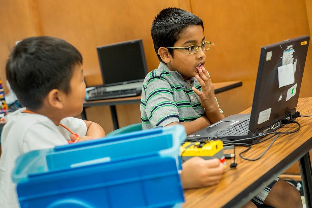 	<p>Kaivalya Kulkarni of Okemos, 8, right, stares at a laptop screen as he write robotics programs, with Ryan Kang of Okemos, 8, July 11, 2013, at Natural Resources Building during Robotics &amp; Nano/Bio Technology camp. Participants have the chance to build robots using materials such as Legos. Justin Wan/The State News</p>