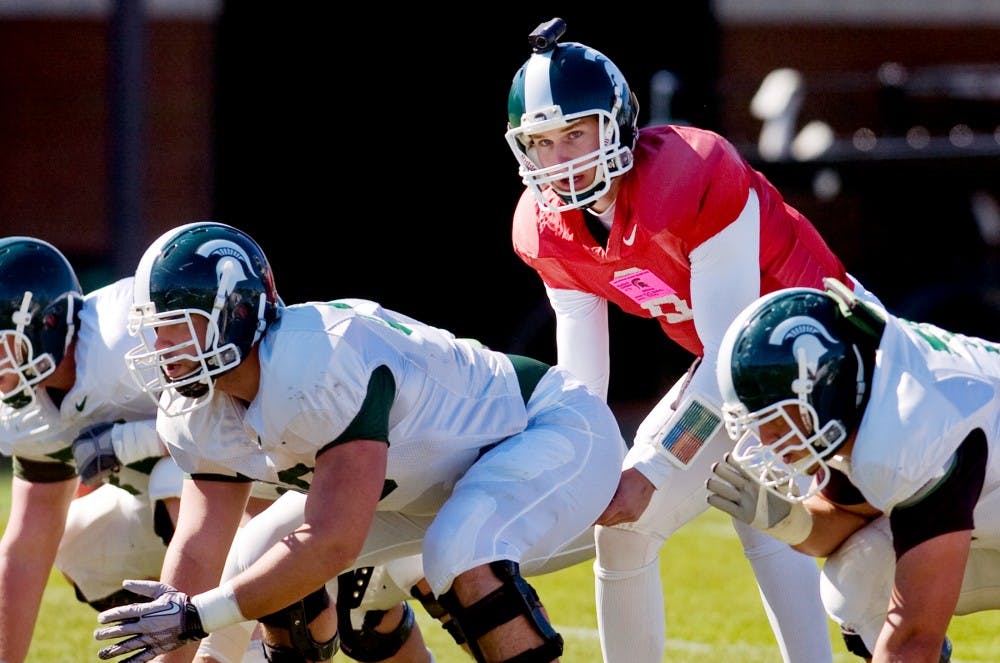 Junior quarterback Kirk Cousins leads the offense during a drill Tuesday outside the Duffy Daugherty Football Building. The Spartans held practice Tuesday in preparation for the 2011 season. Matt Radick/The State News